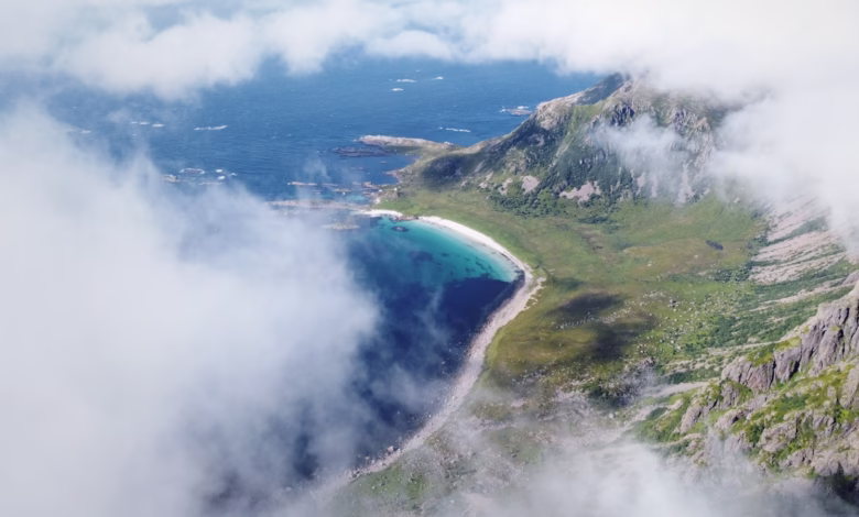 Mountains, sea, and clouds create a scenic view.