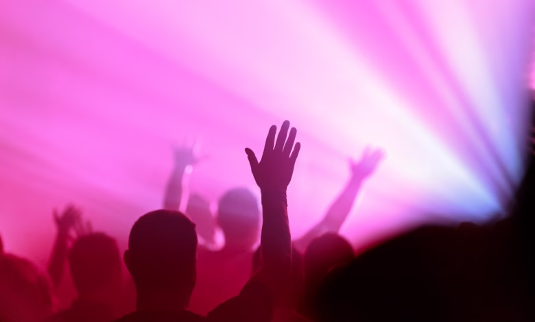 a crowd of people with their hands up in the air