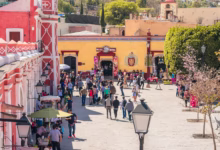 a crowd of people walking down a street next to a yellow building