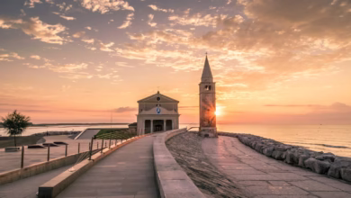 white building beside tower during sunset