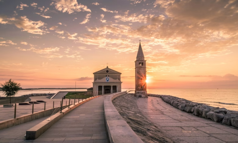 white building beside tower during sunset