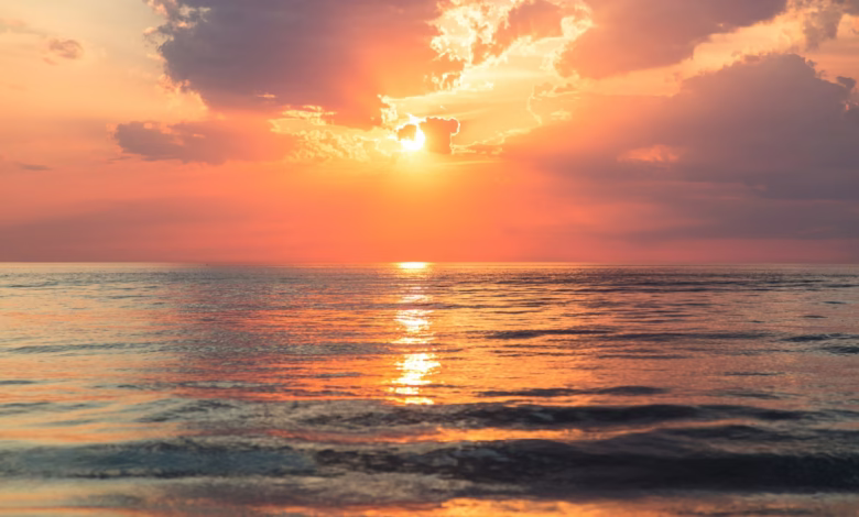 sea under white clouds at golden hour