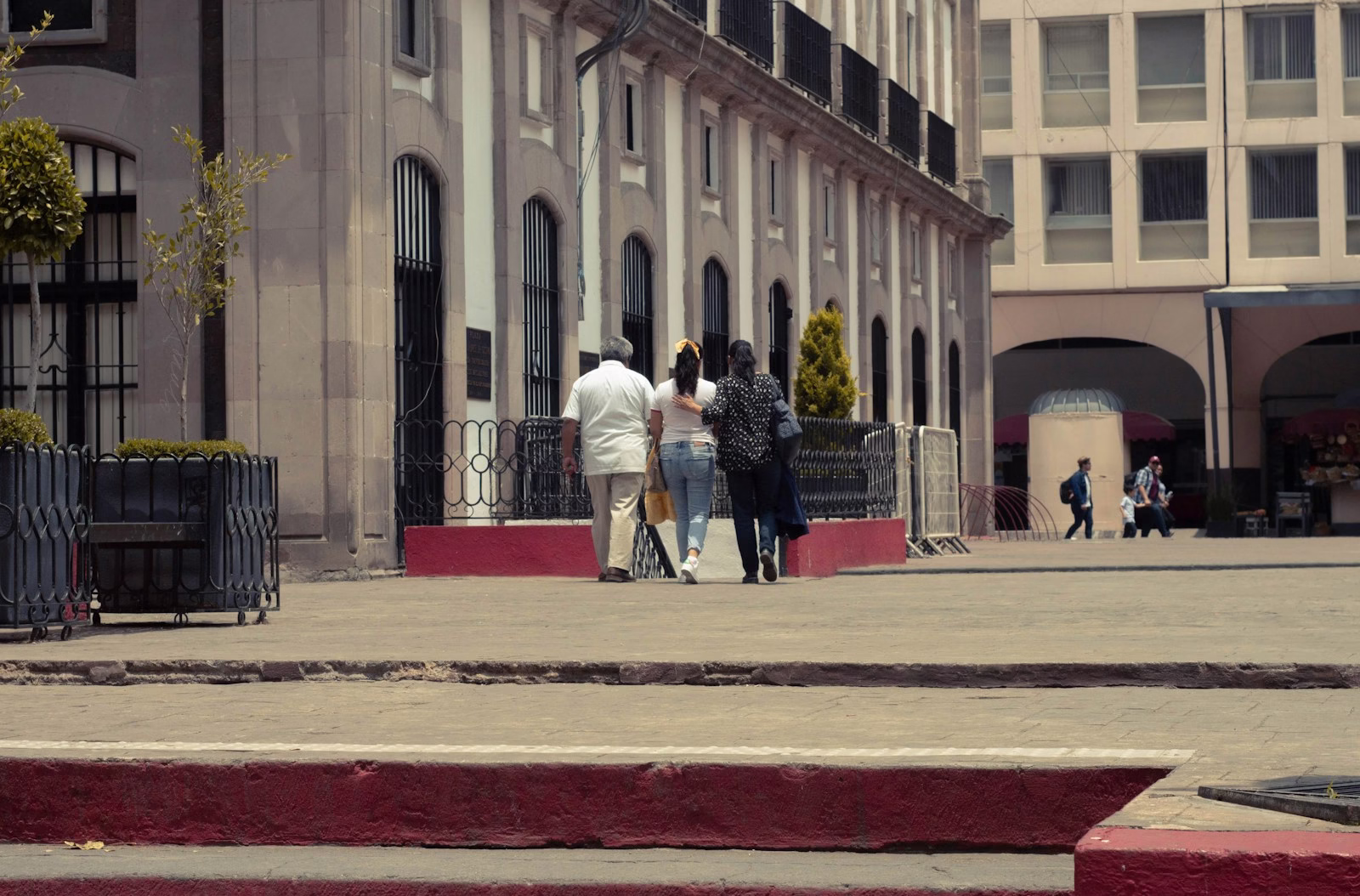 a group of people walking on a sidewalk