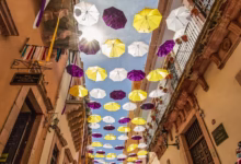 pink and white umbrella hanging on the street
