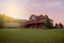 brown wooden house with green grass field