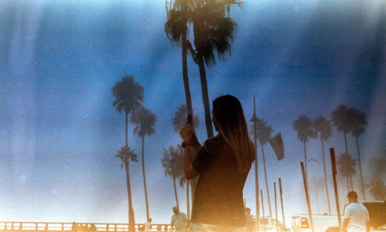 A woman standing in front of a palm tree