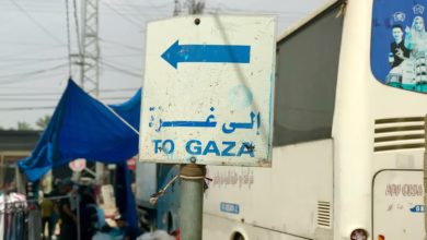 a white bus parked next to a blue and white sign