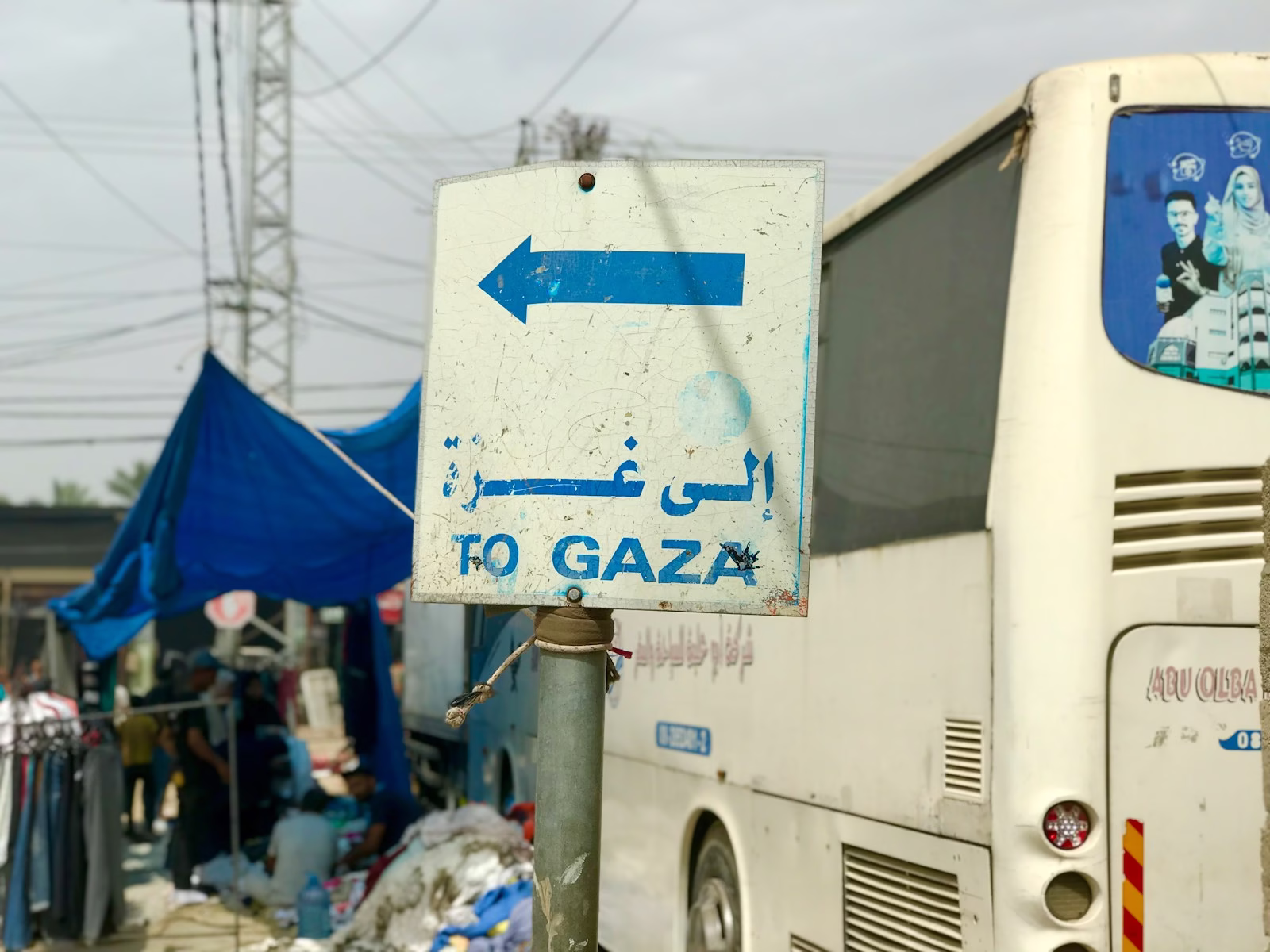 a white bus parked next to a blue and white sign