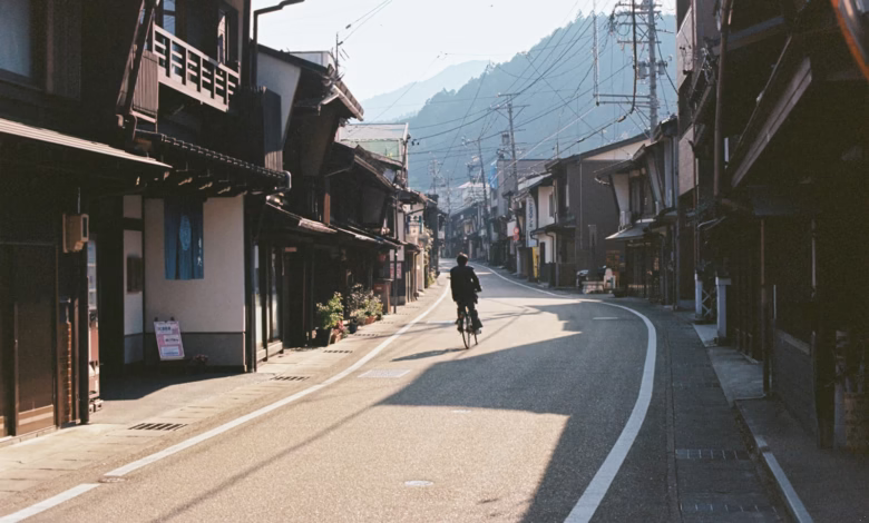 A person rides a bike down a quiet street.