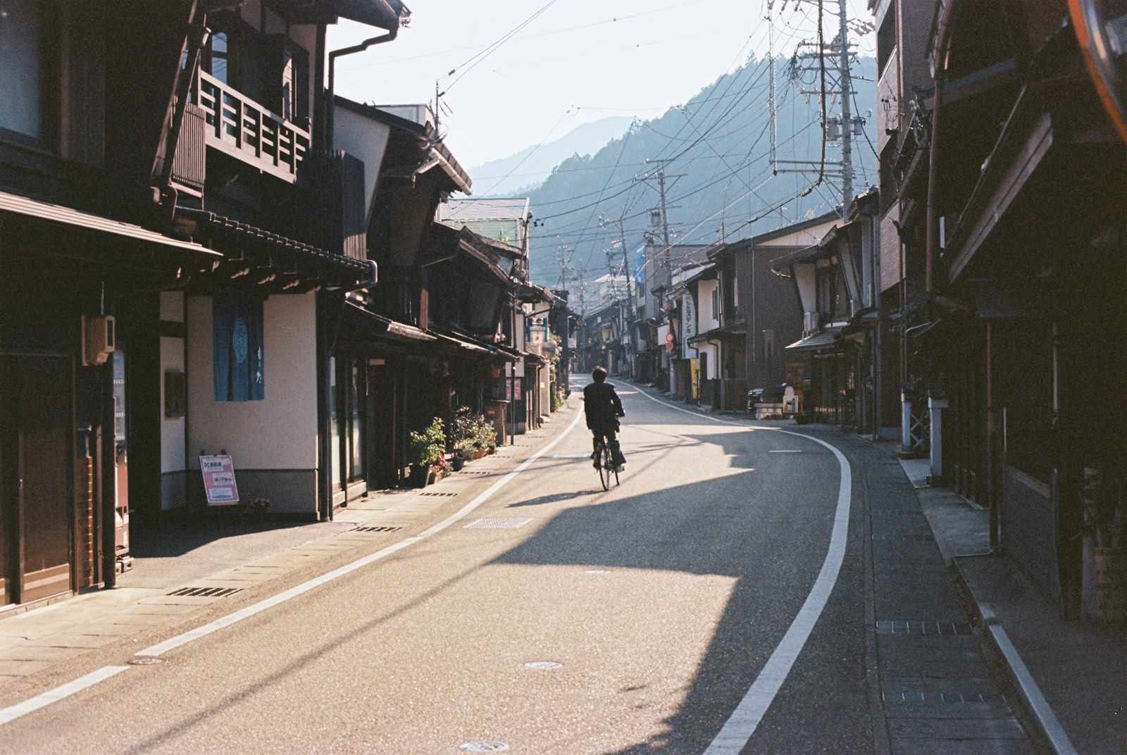 A person rides a bike down a quiet street.