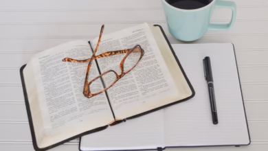 flat lay photography of tortoiseshell eyeglasses on top of book near black pen and teal mug