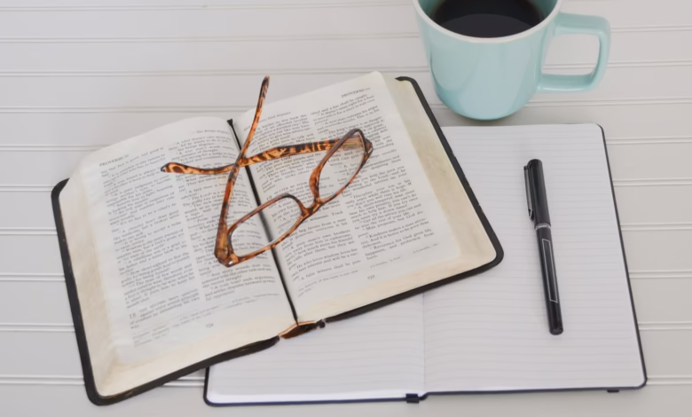 flat lay photography of tortoiseshell eyeglasses on top of book near black pen and teal mug