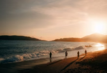 People walking on a beach at sunset
