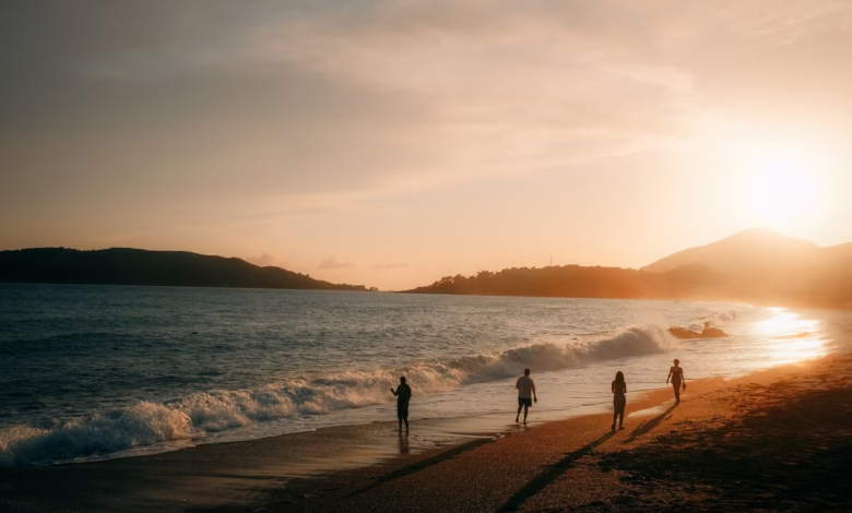 People walking on a beach at sunset