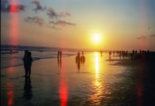 People walking on a beach at sunset