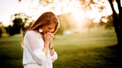 woman praying beside tree