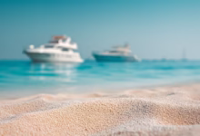 sand, beach, boats, sea, ocean, water, summer, vacation, travel, coast, shore, landscape, horizon, sky, blue, clear, sunny, tourism, nature, yacht, vessel, recreation, relaxation, destination, ai generated