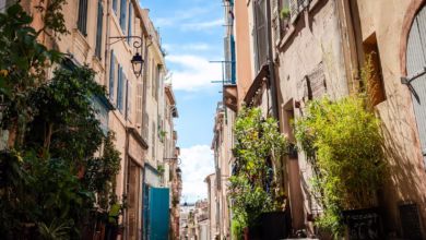 cars parked on sidewalk in between buildings during daytime