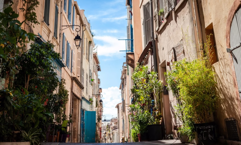 cars parked on sidewalk in between buildings during daytime