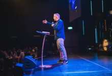 A man standing on top of a stage next to a microphone