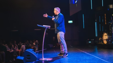 A man standing on top of a stage next to a microphone