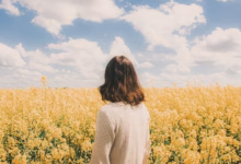 Woman standing in a field of yellow flowers