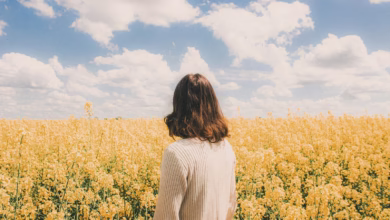 Woman standing in a field of yellow flowers