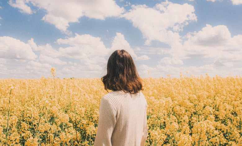 Woman standing in a field of yellow flowers