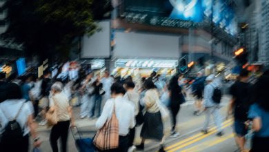 Dynamic urban scene with blurred pedestrians crossing a busy street.