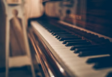 a close up of a piano with a person in the background