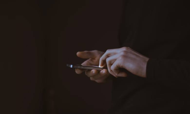 silhouette photo of person holding smartphone