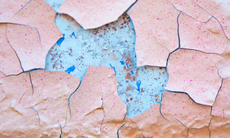 A close up of a piece of paper with paint peeling off of it