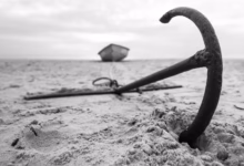 a broken umbrella sitting on top of a sandy beach