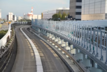 Elevated train tracks curve through a modern cityscape