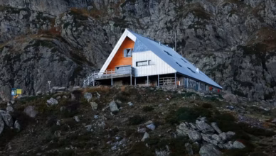 a house on a hill with a mountain in the background