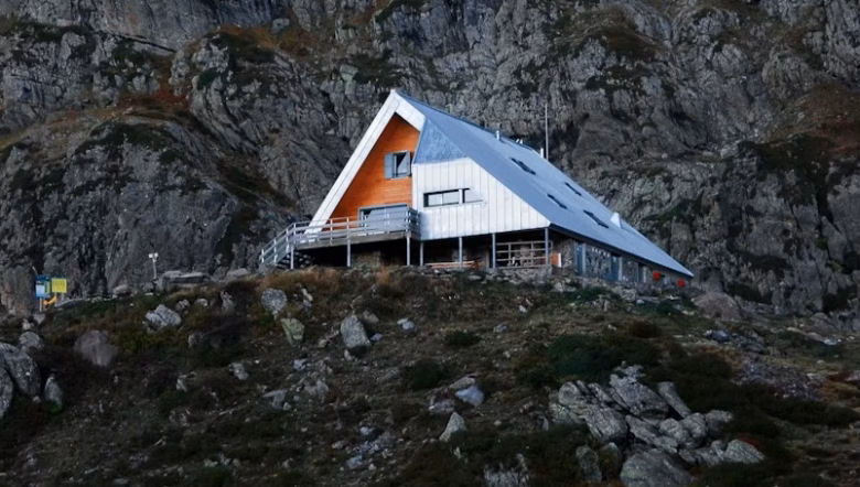 a house on a hill with a mountain in the background