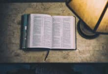open white and blue book beside table lamp