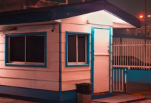 A security guard house stands guard at night